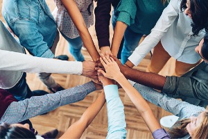 group of people with hands stacked in center